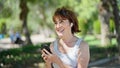 Middle age woman listening to music smiling at park Royalty Free Stock Photo