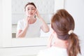 Middle age woman looking in mirror on face. Make up and lifting. Wrinkles and anti aging skin care concept. Selective focus Royalty Free Stock Photo