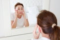 Middle age woman looking in mirror on face. Wrinkles and anti aging skin care concept. Selective focus Royalty Free Stock Photo