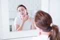 Middle age woman looking in mirror on face. Wrinkles and anti aging skin care concept. Selective focus Royalty Free Stock Photo