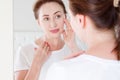 Middle age woman looking in mirror on face. Wrinkles and anti aging skin care concept. Selective focus Royalty Free Stock Photo