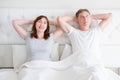 Middle age woman and man resting in bed. Senior couple dreaming and thinking in bedroom. Template and blank t shirt. Copy space