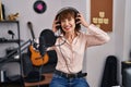 Middle age woman musician smiling confident singing song at music studio