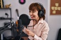 Middle age woman musician smiling confident singing song at music studio