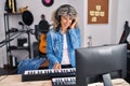 Middle age woman pianist playing piano keyboard at music studio Royalty Free Stock Photo