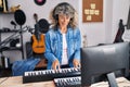 Middle age woman pianist playing piano keyboard at music studio Royalty Free Stock Photo