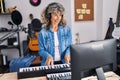Middle age woman pianist playing piano keyboard at music studio Royalty Free Stock Photo