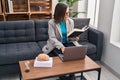 Middle age woman psychologist using laptop reading book at psychology center