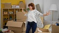 Middle age woman smiling confident standing with arms opened at new home