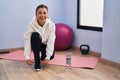 Middle age woman smiling confident tying shoe at sport center Royalty Free Stock Photo