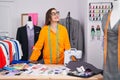 Middle age woman tailor smiling confident standing at tailor shop