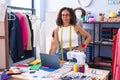 Middle age woman tailor standing at clothing factory