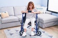 Middle age woman watching video on smartphone sitting on wheelchair at home Royalty Free Stock Photo