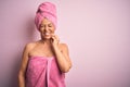 Middle age woman wearing bath towel from beauty body care over pink background touching mouth with hand with painful expression Royalty Free Stock Photo