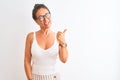 Middle age woman wearing casual t-shirt and glasses standing over isolated white background smiling with happy face looking and Royalty Free Stock Photo