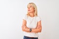 Middle age woman wearing casual t-shirt standing over isolated white background looking to the side with arms crossed convinced Royalty Free Stock Photo