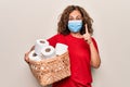 Middle age woman wearing coronavirus protection mask holding big amount of toilet paper for hysteria smiling with an idea or