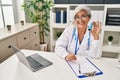 Middle age woman wearing doctor uniform holding inhaler at clinic Royalty Free Stock Photo