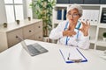 Middle age woman wearing doctor uniform holding inhaler at clinic Royalty Free Stock Photo