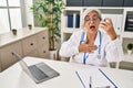 Middle age woman wearing doctor uniform holding inhaler at clinic Royalty Free Stock Photo