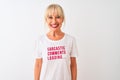 Middle age woman wearing fanny t-shirt with irony comments over isolated white background with a happy face standing and smiling