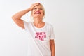 Middle age woman wearing fanny t-shirt with irony comments over isolated white background stressed with hand on head, shocked with