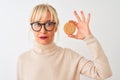 Middle age woman wearing glasses holding cookie standing over isolated white background with a confident expression on smart face Royalty Free Stock Photo