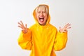 Middle age woman wearing rain coat with hood standing over isolated white background celebrating mad and crazy for success with