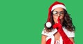 Middle age woman wearing Santa Claus costume asking to be quiet with finger on lips Royalty Free Stock Photo