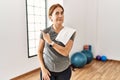 Middle age woman wearing sporty look training at the gym room pointing aside worried and nervous with forefinger, concerned and Royalty Free Stock Photo