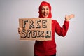 Middle age woman wearing traditional muslim hijab asking for rights holding free speech banner very happy and excited, winner