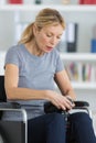 Middle-age woman on wheelchair looking image in camera