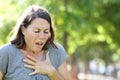 Middle age woman wheezing in a park Royalty Free Stock Photo