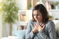 Middle age woman wheezing touching chest at home Royalty Free Stock Photo