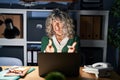 Middle age woman working at night using computer laptop pointing fingers to camera with happy and funny face Royalty Free Stock Photo