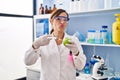 Middle age woman working at scientist laboratory with food looking at the camera blowing a kiss being lovely and sexy Royalty Free Stock Photo