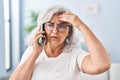 Middle age woman worried talking on the smartphone at home Royalty Free Stock Photo