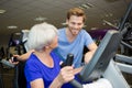 Middle age woman exercising with fitness instructor in gym Royalty Free Stock Photo