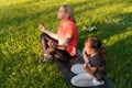 Middle age woman mother with child meditate together in park Royalty Free Stock Photo