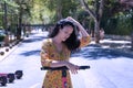 Middle-aged adult Hispanic woman with black curly hair, wearing a colorful outfit, leaning on an electric scooter. Concept scooter Royalty Free Stock Photo