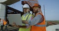 Male engineers discussing plan on construction site Royalty Free Stock Photo