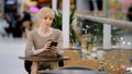 Middle-aged adult 40s caucasian woman businesswoman sitting at cafe table drinking coffee tea looking in mobile phone Royalty Free Stock Photo
