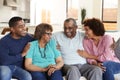 Middle aged African American couple and parents relaxing together at home