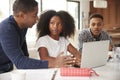 Middle aged African American  man helping his teenage children do their homework using laptop computer Royalty Free Stock Photo