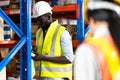 Middle aged African American warehouse worker preparing a shipment in large warehouse distribution centre Royalty Free Stock Photo