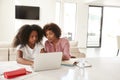 Middle aged African American  woman helping her teenage daughter with homework, front view Royalty Free Stock Photo