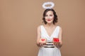 Middle aged angel woman in white dress and nimbus holding gift b