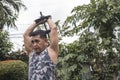 A middle aged asian man does dumbbell overhead triceps extension. Tricep workout done outdoors at the yard Royalty Free Stock Photo