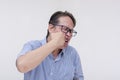 A middle aged asian man punching himself in the face, inflicting self-harm. Isolated on a white backdrop