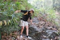 A middle-aged Asian tourist smiled happily. Backpacking in the national park Asian male tourist enjoying his hiking trip